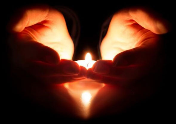 Hands holding a candle